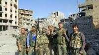 Des forces du régime syrien font le V de la victoire au milieu des destructions dans la ville de Deir Ezzor d'où les jihadistes ont été chassés, le 3 novembre 2017 [STRINGER / AFP]