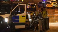 Des spectateurs près d'une salle de concerts à Manchester le 23 mai 2017, où une possible attaque terroriste a fait 19 morts et une cinquantaine de blessés [Paul ELLIS / AFP]