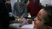 Des médecins syriens examinent une enfant dans un hôpital de fortune après des bombardements du régime syrien sur la ville de Douma dans la Ghouta orientale, le 22 février 2018 [Hamza AL-AJWEH / AFP]