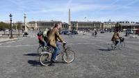Des gens à bicyclette place de la Concorde à Paris  [Patrick Kovarik / AFP/Archives]