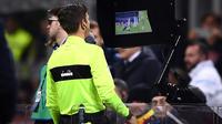 L'arbitre italien Gianluca Rocchi recourt à la vidéo pour juger une situation litigieuse lors du match Inter Milan-Lazio du 20 décembre 2017 à San Siro [Marco Bertorello / AFP/Archives]