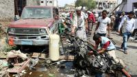 Le 13 mars 2018 à Aden au Yémen, des yéménites inspectent l'épave d'une voiture détruite par l'attentat suicide [SALEH AL-OBEIDI / AFP]