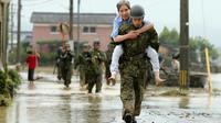 Des militaires japonais aident la population à évacuer, le 6 juillet 2017 à Asakura [STR / JIJI PRESS/AFP]