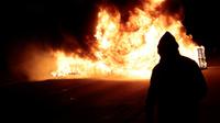 Un manifestant devant un feu allumé près de la prison de Fleury-Mérogis, dans l'Essonne près de Paris,  le 10 avril 2017 [GEOFFROY VAN DER HASSELT / AFP]