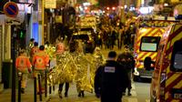 Des victimes, des pompiers et des policiers aux abords du Bataclan à Paris dans la soirée du 13 au 14 novembre 2015 [MIGUEL MEDINA / AFP/Archives]