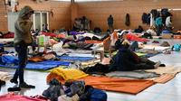 Des migrants kurdes et afghans s'apprêtent à dormir dans un gymnase de Grande-Synthe, près de Dunkerque, le 7 février 2018 [Denis Charlet / AFP/Archives]