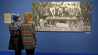 Des visiteurs d'une exposition en Pologne consacrée à Frida Kahlo et son époux contemplent une photo d'une toile disparue depuis plus d'un demi-siècle de l'artiste mexicaine, La table blessée, le 28 novembre 2017 à Poznan [JANEK SKARZYNSKI / AFP]