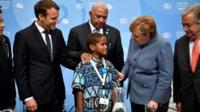 Timoci Naulusala un petit fidjien est félicité par le président Emmanuel Macron (g) et la chancelière Angela Merkel après son discours devant la COP 23 à Bonn [ / AFP]