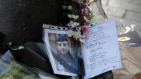 Photo du policier tué et hommage le 21 avril 2017 sur le lieu où il a été assassiné sur les Champs Elysée la veille [FRANCOIS GUILLOT / AFP]