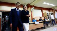 Moon Jae-In Moon Jae-In, le candidat du Parti démocratique de centre-gauche, et son épouse dans un bureau de vote, à Séoul le 9 mai 2017 [JEON HEON-KYUN / POOL/AFP]