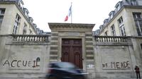 Des militants d'associations de défense des migrants ont tagué "accueil de merde" sur la façade du ministère du Logement à Paris le 16 décembre 2017 pour dénoncer les conditions de réception des migrants en France [Thomas SAMSON / AFP]