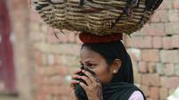 Une "intouchable" transporte sur sa tête un panier rempli d'excréments humains, le 10 août 2012 dans le village de Nekpur, en Inde [Prakash Singh / AFP]