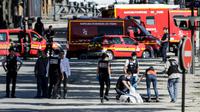 Des membres de la police judiciaire enveloppent le corps de l'auteur de l'attentat raté sur les Champs-Elysées à Paris, le 19 juin 2017 [Thomas SAMSON / AFP]