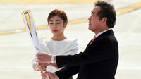 Le Premier ministre sud-coréen Lee Nak-Yon (d) et la médaille d'or du patinage artistique Kim Yu-Na portent la flamme olympique, le 1er novembre 2017 à l'aéroport de Séoul lors d'une cérémonie pour son arrivée en Corée du Sud [JUNG Yeon-Je / AFP]
