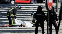 Des policiers recouvrent le corps d'un assaillant, après un attentat avorté sur les Champs-Élysées, le 19 juin 2017 à Paris [Thomas SAMSON / AFP]