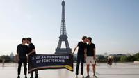 Des militants d'Amnesty s'embrassent devant la tour Eiffel à Paris dans le cadre d'une manifestation contre l'homophobie en Tchétchénie, le 29 mai 2017 [GEOFFROY VAN DER HASSELT / AFP]