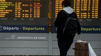 Un passager regarde un tableau d'affichage des vols à l'aéroport Roissy Charles-de-Gaulle, près de Paris lors d'une grève le 26 janvier 2016 [KENZO TRIBOUILLARD / AFP/Archives]