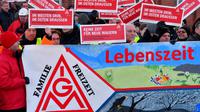 Des ouvriers de l'usine Bombardier brandissent des panneaux au logo du syndicat allemand de la métallurgie IG Metall, à Hennigsdorf près de Berlin (nord-est), le 8 janvier 2018 [Bernd Settnik / dpa/AFP]
