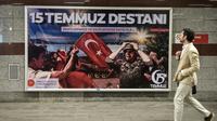 Un homme passe devant une affiche "La légende du 15 juillet", le 14 juillet 2017, à la veille de l'anniversaire de la tentative de coup d'Etat en Turquie. [OZAN KOSE / AFP]
