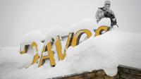 Un membre du service de sécurité, en tenue de camouflage, monte la garde sur le toit d'un hôtel à Davos (Suisse) le 22 janvier 2018 [Fabrice COFFRINI / AFP]