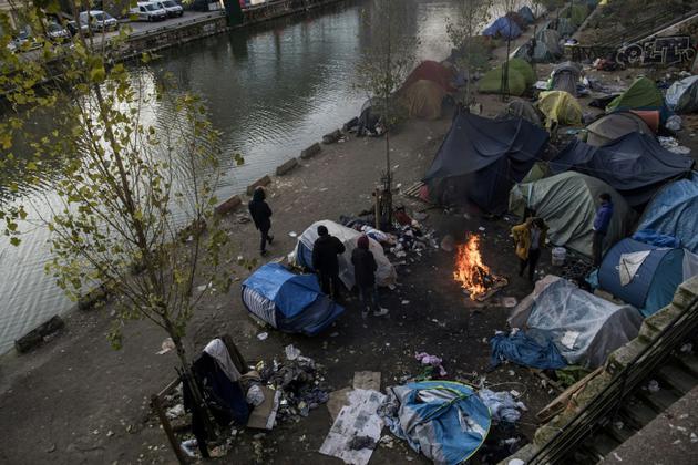 Des migrants se réchauffent autour d'un feu, le 23 février 2018 à Paris où un froid sibérien est attendu [CHRISTOPHE ARCHAMBAULT  / AFP]