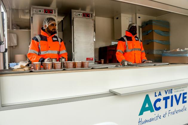 Des membres de l'association Vie Active, mandatée par l'Etat, se préparent pour la distribution de repas aux migrants de Calais, le 6 mars 2018 [Philippe HUGUEN / AFP]