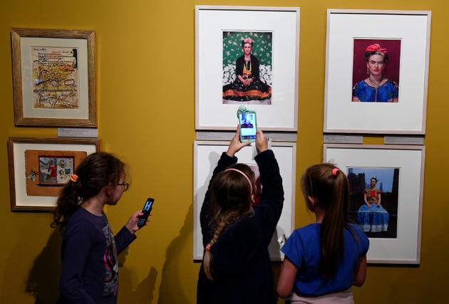 Des enfants visitant l'exposition Frida Kahlo à Poznan en Pologne prennent des photos de plusieurs autoportraits de l'artiste, le 28 novembre 2017 [JANEK SKARZYNSKI / AFP]
