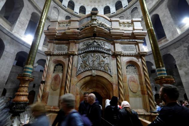 Le tombeau où le Christ a été enterré selon la tradition, paré de ses nouvelles couleurs dans l'église du Saint-Sépulcre à Jérusalem, le 21 mars 2017 [Gali TIBBON / AFP]