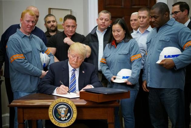 Donald Trump signant les taxes sur les importations d'acier et d'aluminium aux côtés de travailleurs du secteur à la Maison Blanche le 8 mars 2018 [MANDEL NGAN / AFP]