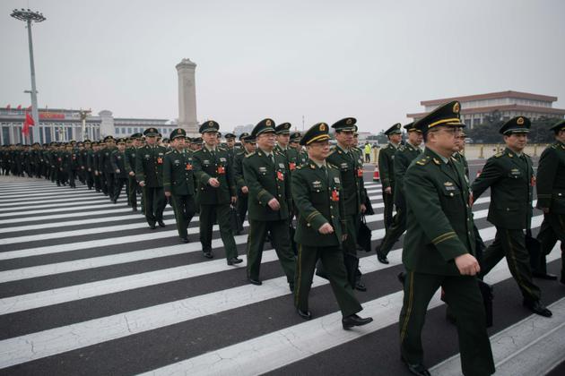 Des délégués militaires arrivent à Pékin, le 11 mars 2018 à l'Assemblée nationale populaire pour le vote sur le changement de Constitution [NICOLAS ASFOURI / AFP]