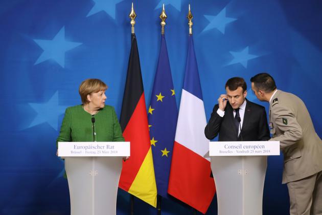 Le président français Emmanuel Macron, informé de la prise d'otages à Trèbes, pendant une conférence de presse avec la chancelière allemande Angela Merkel à Bruxelles le 23 mars 2018 [Ludovic MARIN / AFP]