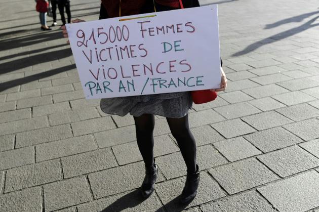 Une femme tient un panneau où l'on peut lire "21.500 femmes victimes de violence par an en France", sur le Vieux Port à Marseille, lors d'un rassemblement contre les violences faites aux femmes le 29 octobre 2017 [Franck PENNANT / AFP]