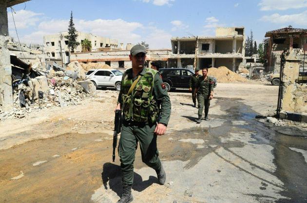 Photo obtenue auprès de l'agence officielle syrienne SANA le 15 avril 2018 montrant des membres des forces du régime dans Douma après le départ des derniers combattants rebelles de la ville [HO / SANA/AFP]
