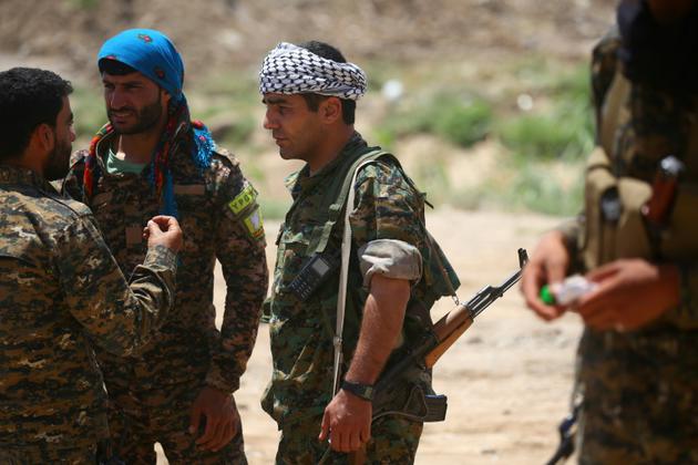 Des membres de la force kurdo-arabe soutenue par les Etats-Unis, le 11 juin 2017 dans un quartier de Raqa, fief du groupe Etat islamique (EI) en Syrie [DELIL SOULEIMAN / AFP]