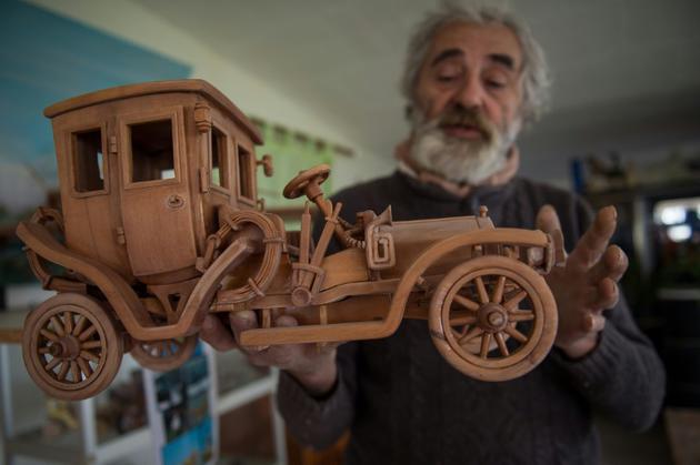 Le 20 mars 2017, à Loches, Michel Robillard présente un modèle réduit de voiture en bois [GUILLAUME SOUVANT / AFP/Archives]