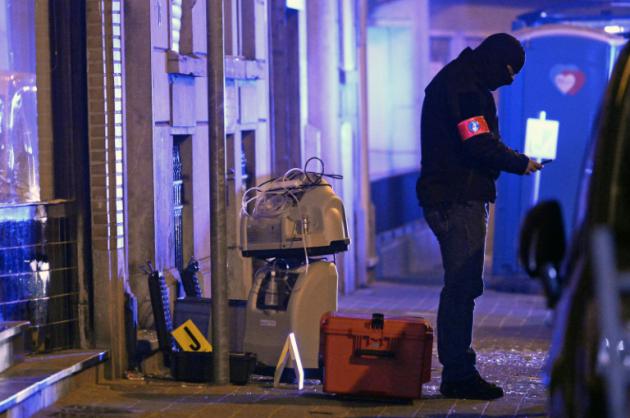 Un enquêteur est à la recherche d'indices, le 19 mars 2016 à Molenbeek à l'extérieur du bâtiment où a été arrêté la veille Salah Abdeslam [DIRK WAEM / Belga/AFP/Archives]