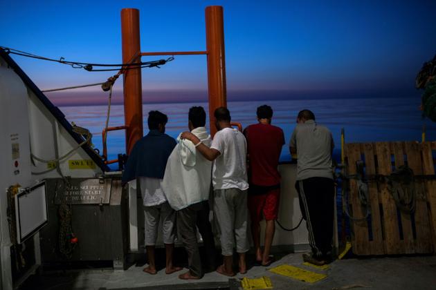 Des migrants regardent le soleil levant à bord de l'Aquarius en mer Méditerrannée le 16 août 2017 [Angelos Tzortzinis / AFP/Archives]