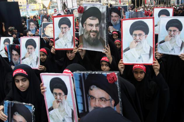 Des enfants de membres du Hezbollah brandissent des portraits du leader du mouvement chiite libanais Hassan Nasrallah et du guide suprême iranien, l'ayatollah Ali Khamenei, lors d'une procession après la cérémonie de l'Achoura à Nabatiyeh, dans le sud du Liban, le 4 octobre 2017 [Mahmoud ZAYYAT / AFP]
