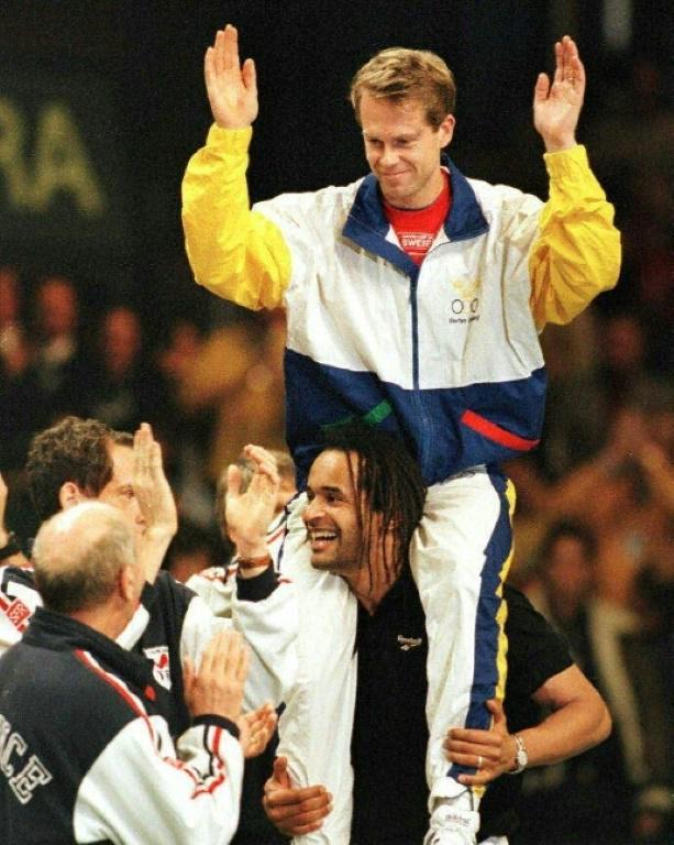Honneur au vaincu: Yannick Noah porte Stefan Edberg sur ses épaules, le 1er décembre 1991 à Malmö après le dernier match de la carrière du Suédois, une défaite en finale de la Coupe Davis  [JEAN-LOUP GAUTREAU / AFP/Archives]