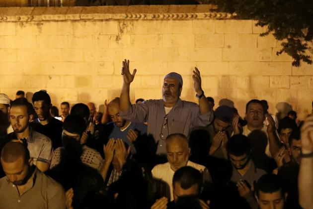 Des Palestiniens musulmans prient devant le Vieille ville de Jérusalem, le 25 juillet 2017 [Ahmad GHARABLI / AFP]