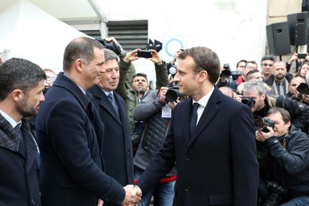 Emmanuel Macron serre la main du président de l'exécutif corse Gilles Simeoni (à gauche) lors de l'hommage au préfet Claude Erignac le 6 février 2018 à Ajaccio [ludovic MARIN / POOL/AFP]