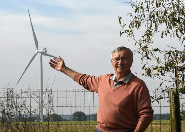 Le maire de Montagne-Fayel, Jean-Marie Turlot, montre une éolienne installée près d'une maison [FRANCOIS LO PRESTI / AFP]