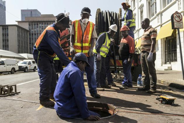 Des techniciens descendent dans un tunnel sous Johannesburg, le 8 septembre 2017 [TADEU ANDRE / AFP]