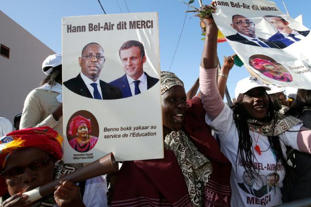 Des Sénégalaises saluent le passage d'Emmanuel Macron et de Macky Sall à Dakar, le 2 février 2018 [PHILIPPE WOJAZER / POOL/AFP]
