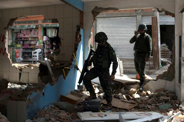Des soldats brésiliens inspectent les décombres d'un poste de police détruit à Rio, le 30 novembre 2017 [LEO CORREA / AFP/Archives]