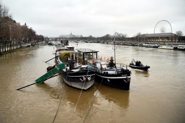 Les habitants des péniches amarrées sur les berges de la Seine ont installé des défenses afin que leurs bateaux n'aillent pas s'échouer sur les quais, à Paris le 22 janvier 2018 [CHRISTOPHE SIMON / AFP]