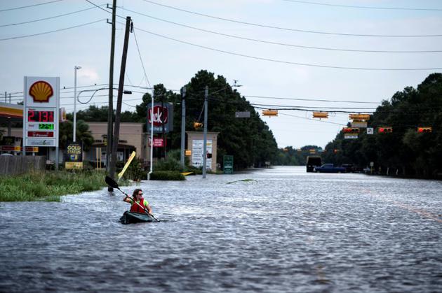 Une femme navigue dans un canoë sur une route inondée de Houston, après le passage de l'ouragan Harvey, le 30 août 2017 [Brendan Smialowski / AFP/Archives]