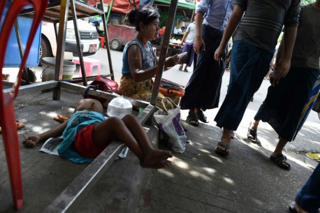 A Rangoon, le 1er octobre 2016, une vendeuse de rue et son enfant endormi [ROMEO GACAD / AFP/Archives]