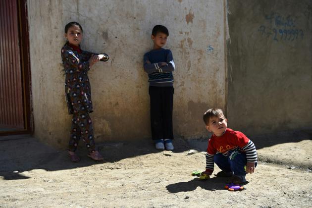 Le petit Donald Trump (à droite) joue avec sa soeur Fatemah et son frère Kareem à leur domicile de Kaboul, le 16 mars 2018 [Wakil KOHSAR / AFP]