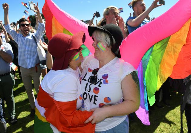 Un couple de même sexe s'embrasse le 15 novembre 2017 à Sydney à l'annonce de la victoire du "oui" au mariage gay lors d'une vote postal [WILLIAM WEST / AFP]